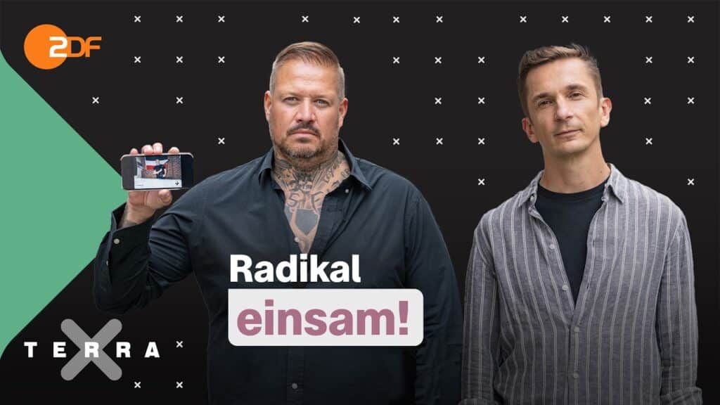 Zwei Männer stehen vor einem schwarzen Hintergrund mit weißen X's. Philip Schlaffer, links, hält ein Smartphone hoch. In der Mitte des Bildschirms erscheinen "Radikal einsam!" und "Terra X", in der linken oberen Ecke das ZDF-Logo.